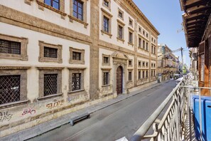 Une vue de rue avec des bâtiments, un ciel dégagé et un trottoir pour les piétons.