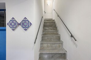 A staircase with marble steps and metal handrails, leading to a landing with a light fixture. - Apartment 'Le Stanze Del Sole - Blu' with Balcony and Air Conditioning (Palermo)