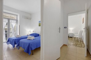 Ein Hotelzimmer mit zwei Betten, einem Balkon und einer Essecke.
