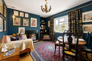 A room with a fireplace, a dining table set for two, and a large window with curtains. - Artful Hoxton Flat with Private Balcony - Pass the Keys (London)