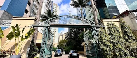 Una entrada cerrada a un complejo de edificios, con dos coches estacionados al frente.