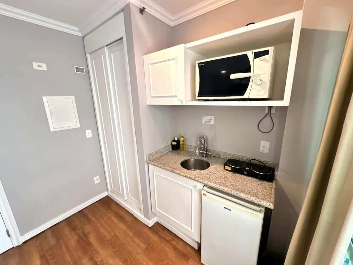 A compact kitchen with a built-in microwave, a sink, and a dishwasher.