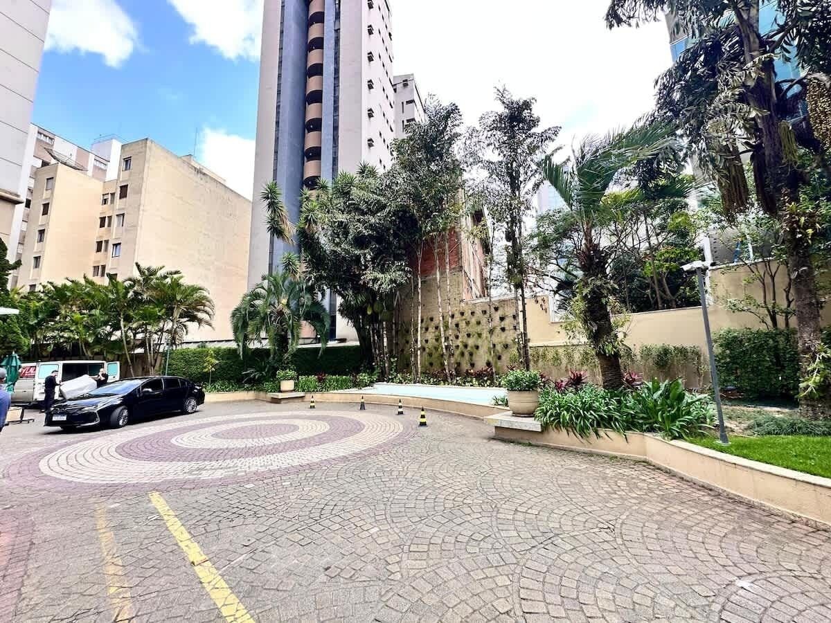 A paved courtyard with a circular pattern, surrounded by buildings and greenery.
