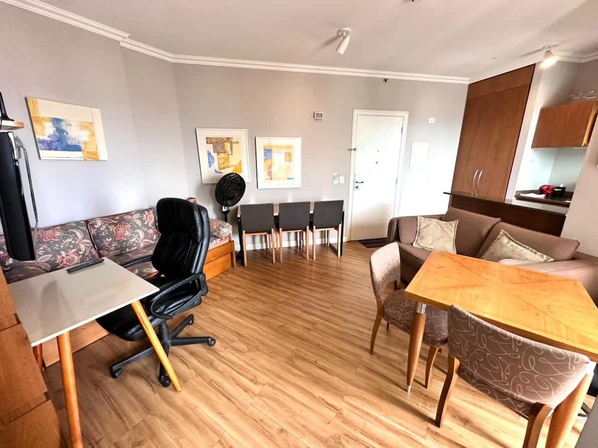 Ein Wohnzimmer mit einer Couch, einem Esstisch, einem Couchtisch und einem Fernseher.