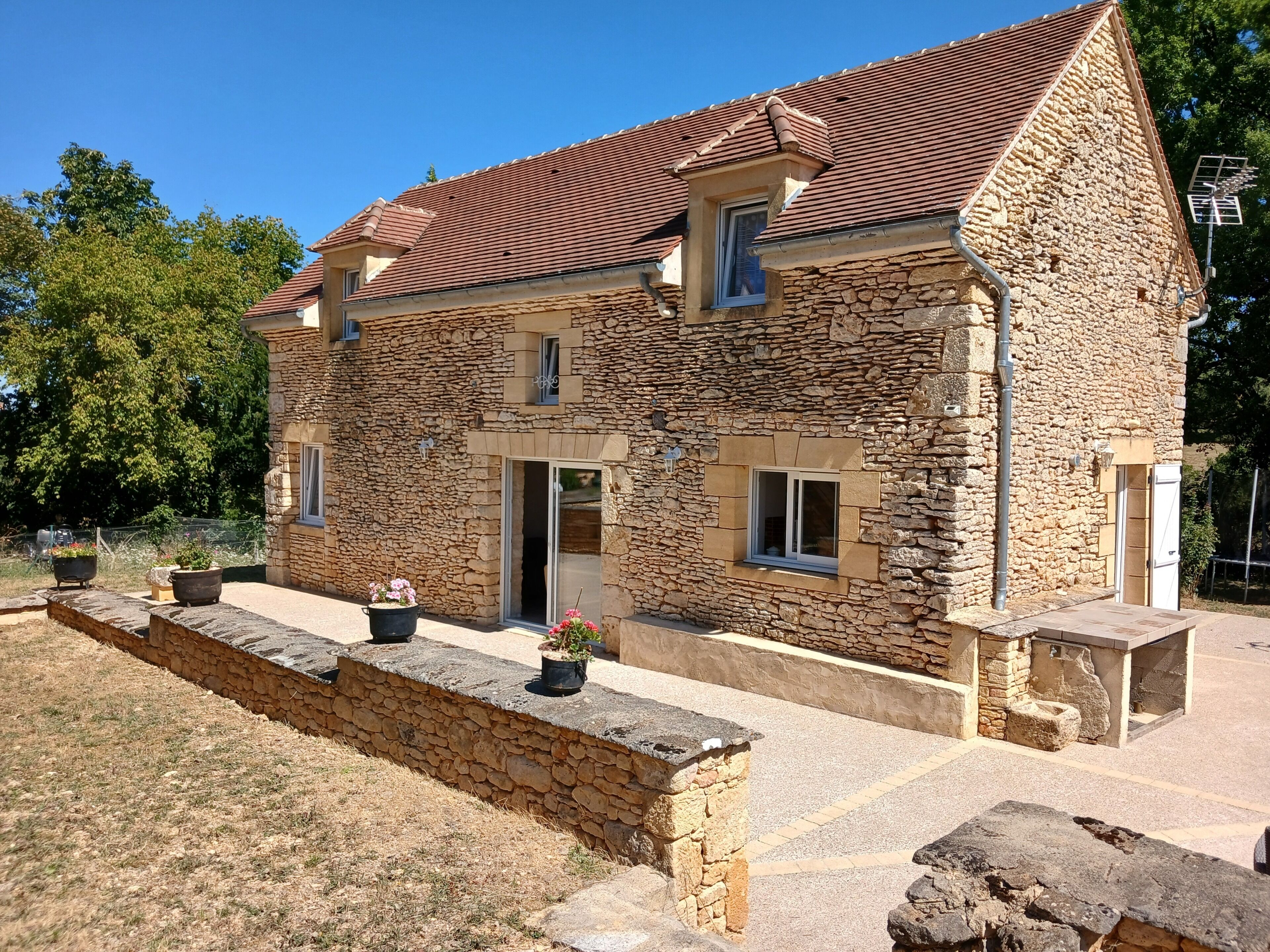 A stone building with a sloped roof, a front door, and a small window.