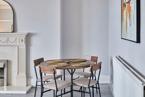 Ein Essbereich mit einem runden Tisch, vier Stühlen und gewebten Tischsets.