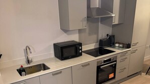 A modern kitchen with a built-in microwave, toaster, and oven. - Apartment in Botanical Gardens, Old Trafford (Manchester)
