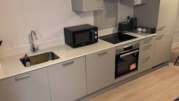 A modern kitchen with a built-in microwave, toaster, and oven.