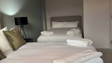 Een hotelkamer met een groot bed, een bedlampje en netjes opgevouwen handdoeken.