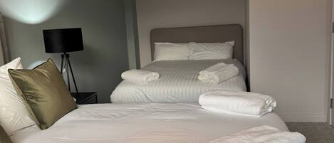 A hotel room with a large bed, a bedside lamp, and neatly folded towels.