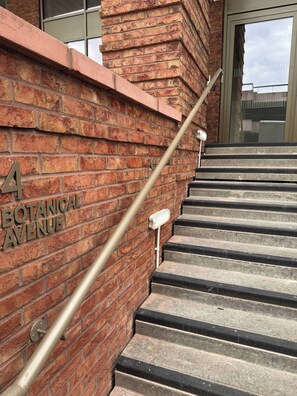 A brick wall with the text '4 BOTANICAL AVENUE' and a metal handrail leading up a set of concrete stairs. - Apartment in Botanical Gardens, Old Trafford (Manchester)