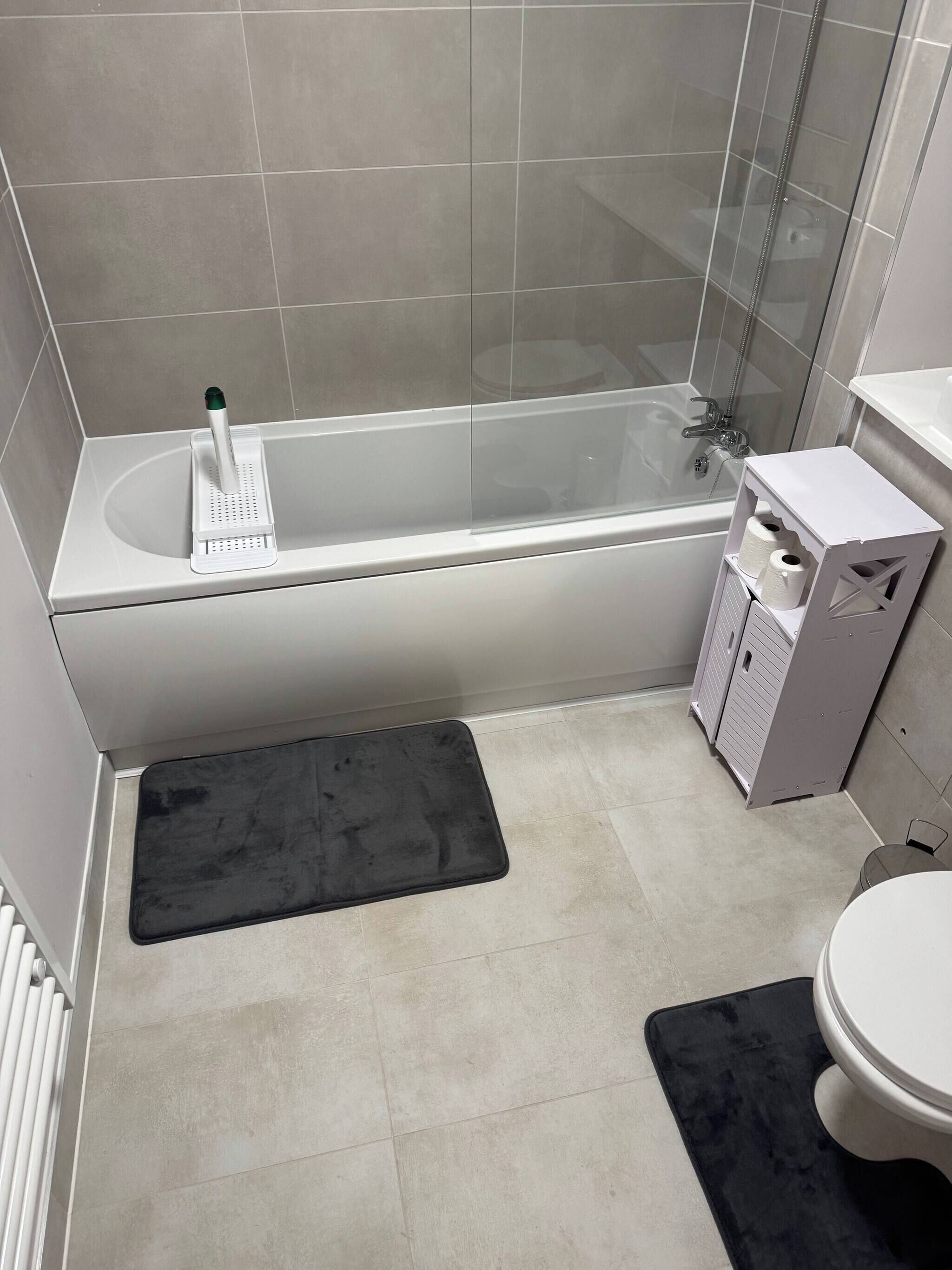 Een badkamer met een bad, toilet en douche.