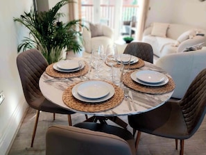 A dining table set with plates, cutlery, and glasses, surrounded by upholstered chairs. - 2 Bedroom 2 Bathroom Designer Apt Free Parking Finchley Central (London)