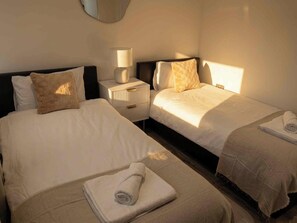 A hotel room with two beds, a bedside table with a lamp, and a mirror on the wall. - 2 Bedroom 2 Bathroom Designer Apt Free Parking Finchley Central (London)