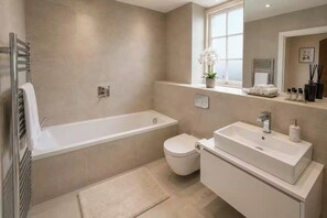 A modern bathroom with a bathtub, toilet, and sink. - 2 Bedroom 2 Bathroom Designer Apt Free Parking Finchley Central (London)