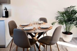 A dining area with a round table set for four, equipped with plates, glasses, and cutlery. - 2 Bedroom 2 Bathroom Designer Apt Free Parking Finchley Central (London)