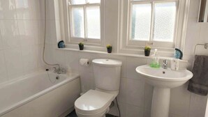 A bathroom with a bathtub, toilet, and sink. - 1BR Apartment in Chislehurst High Street Sleeps 3 (Chislehurst)
