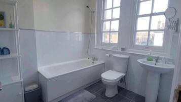 A bathroom with a bathtub, toilet, and sink.