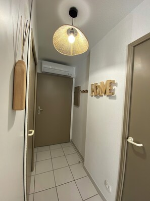 Ein Flur mit Deckenventilator, einer Tür mit der Aufschrift 'HOME' und einer Wand-Klimaanlage.