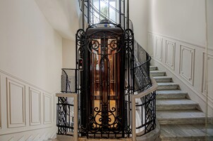 A staircase with a wrought iron railing and a glass door at the top.