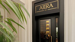 Una entrada enmarcada en negro con el nombre 'AJIRA' en letras doradas.
