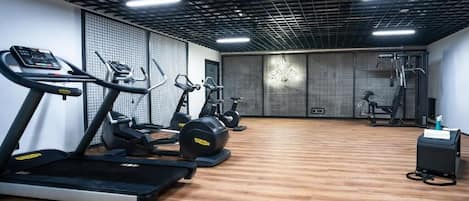 A gym with treadmills, elliptical machines, and weight equipment.
