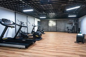 Ein Fitnessstudio mit Laufbändern, Crosstrainern und Gewichtsmaschinen.