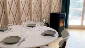 Un tavolo da pranzo rotondo apparecchiato per quattro persone, con piatti, posate e bicchieri di vino.