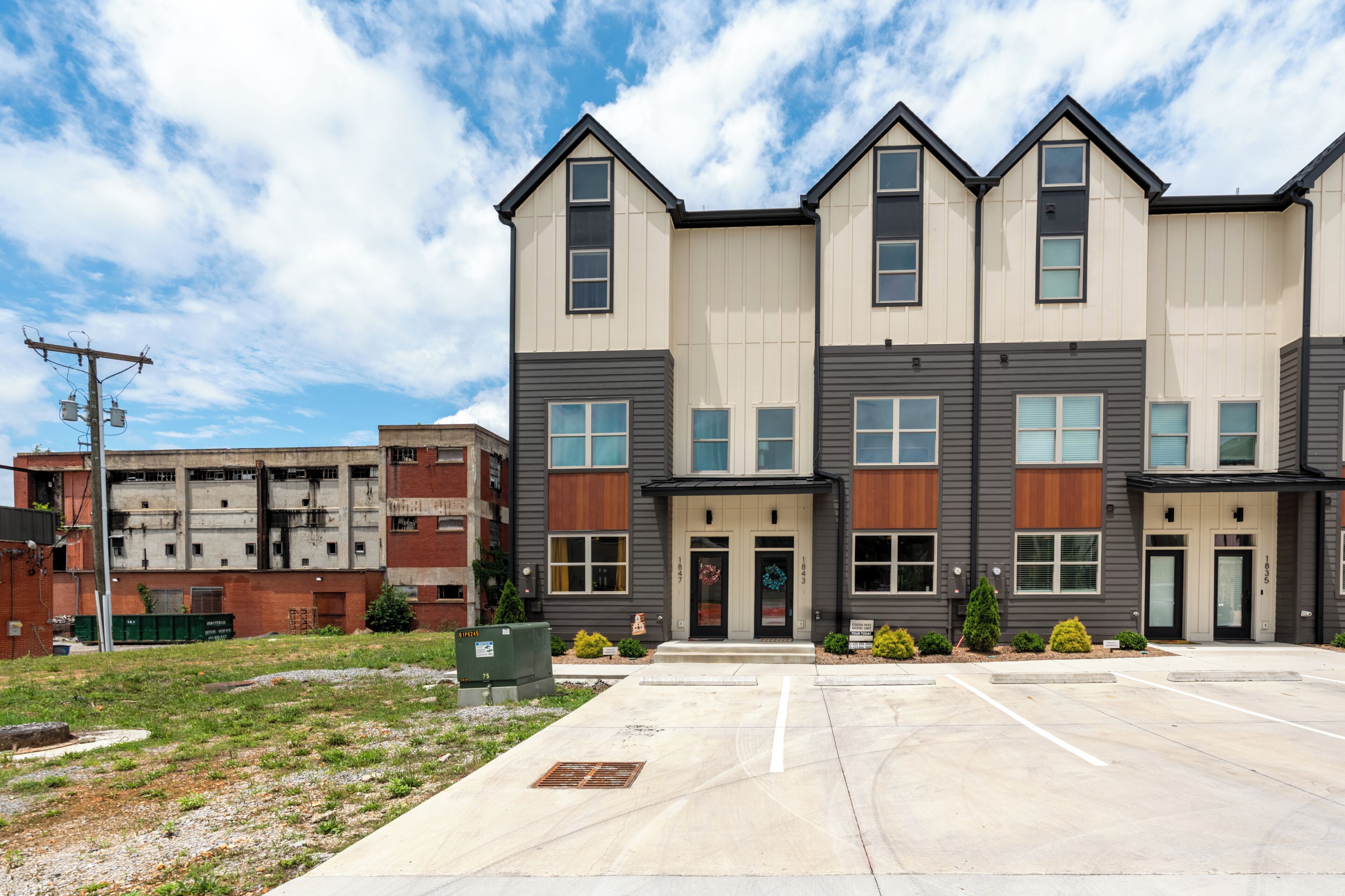 A multi-story building with a parking lot in front.