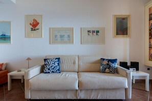 A living room with a beige sofa, two side tables, and framed artwork on the wall. - A spacious and bright apartment of approximately 70 sqm, perfect for 4 people, located on the first lower-ground floor of a building with an elevator (not suitable for wheelchair users).The property is situated in Taormina - one of Sicily's gems - in an  (Taormina)