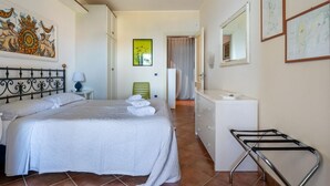 Een hotelkamer met een bed, een dressoir, een spiegel en kunstwerken aan de muur.