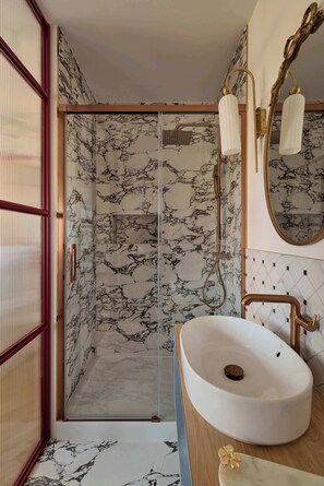 A bathroom with a marble shower, a white sink, and a wooden vanity. - Bema Atelier Bath & Marble Suite | Near Beach (Sopot)