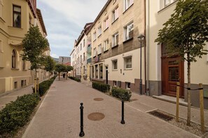 A pedestrian street lined with multi-story buildings, some with balconies and awnings, and a clear sky above. - Bema Atelier Bath & Marble Suite | Near Beach (Sopot)