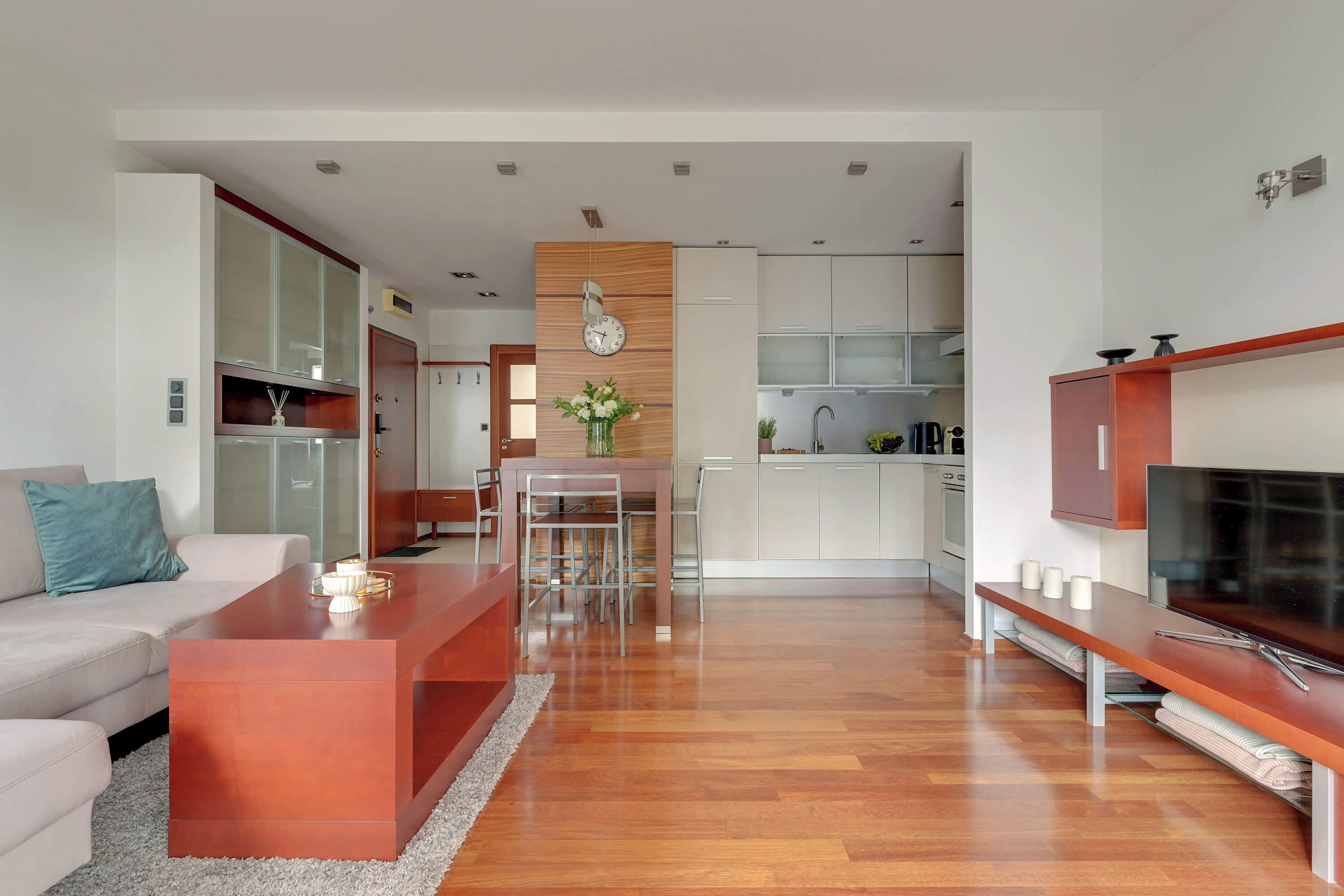 A modern living room with a sofa, coffee table, and TV stand.