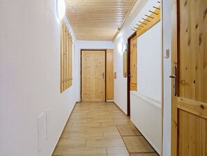 A hallway with wooden floors, white walls, and wooden doors with metal handles. - Cosy apartment in villa for 12 people with WIFI, TV and patio (Vrchlabí)