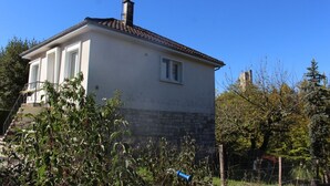 A two-story house with a chimney, a small window, and a staircase leading to the upper floor. - Holiday Home 'Maison Vue Sur La Tour' with Private Terrace, Wi-Fi and Air Conditioning (Montcuq-en-Quercy-Blanc)