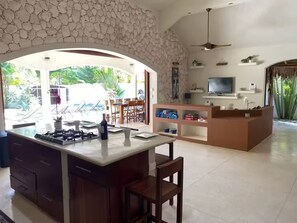 A spacious living area with a kitchen island, dining area, and a television. - 4BR Tropical Villa with Private Pool - 2 Min to Beach (Las Terrenas)