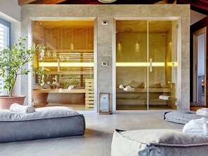 A modern interior with a glass partition, a seating area with cushions, and a potted plant. - Nice apartment for 4 people with WIFI and TV (Rosignano Monferrato)
