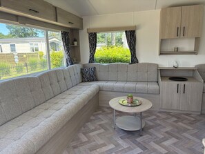 Ein moderner Wohnraum mit Ecksofa, rundem Couchtisch und integrierten Schränken.