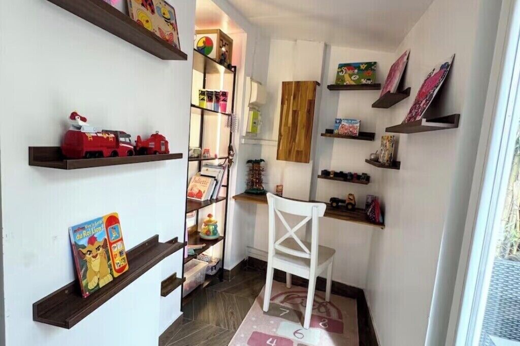 Un pasillo estrecho con estantes en las paredes, una silla blanca y un tapete estampado.