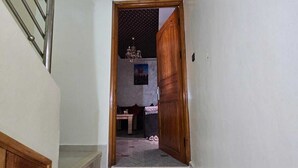 A staircase leading to a room with a wooden door, a small table, and a chair. - Wonderful 2-bedroom condo in Essaouira perfect for relaxing stays (Essaouira)