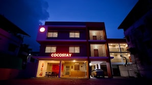 A multi-story hotel with a prominent 'COCOSAY' sign, a covered entrance, and a car parked in front. - Cocostay Kozhikode (Kozhikode)