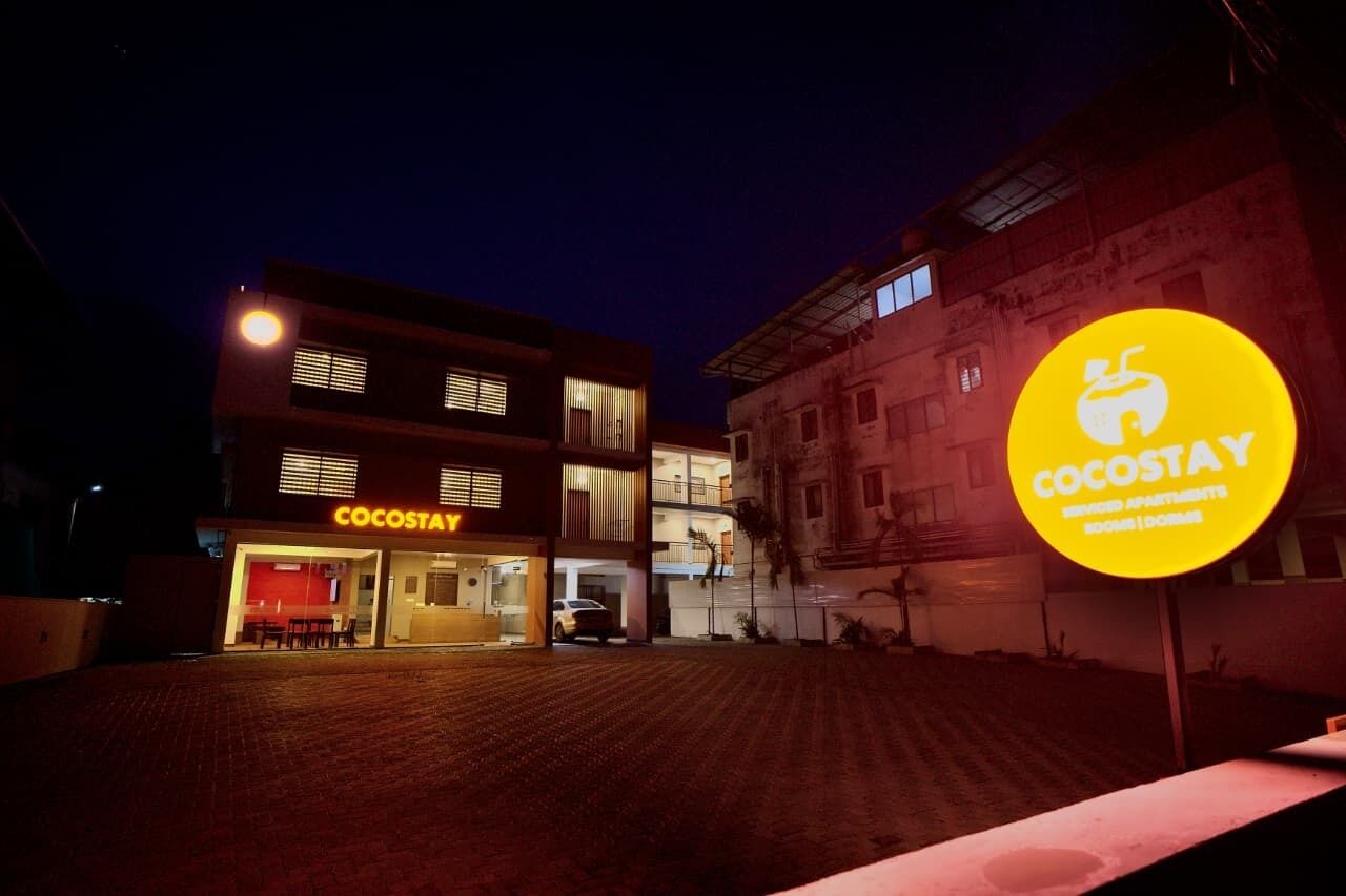 Un edificio con un letrero que dice 'COCOSAT' y un letrero circular brillante que dice 'COCOSAT'.