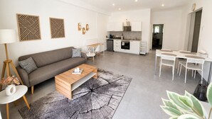 A modern apartment with a living area, kitchenette, and dining space. - Apartment mit Terrasse (Bielefeld)