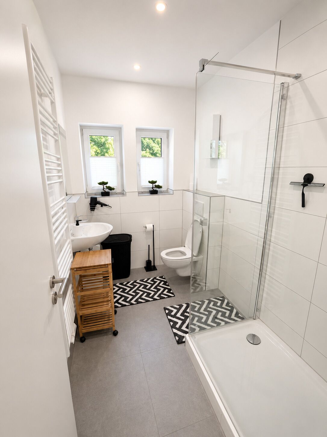 Een moderne badkamer met douche, toilet en wastafel.