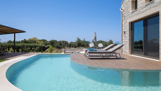 Uma piscina com espreguiçadeiras e um pérgola.