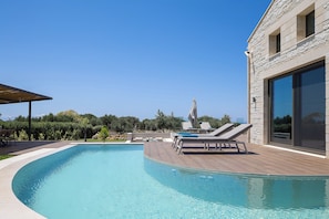 A swimming pool with lounge chairs and a pergola. - Twin Revi Villas | Private Retreat in Stavros (Stavros)