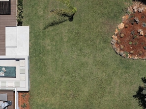 A top-down view of a landscaped area with a pool, seating area, and a variety of plants. - Twin Revi Villas | Private Retreat in Stavros (Stavros)