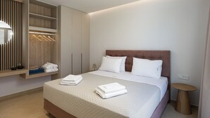 Quarto de hotel com uma cama, um guarda-roupa, uma mesa de cabeceira e um espelho.