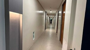 Pitkä, kapea käytävä, jonka molemmilla puolilla on ovia, ja joka johtaa erillisiin huoneisiin.